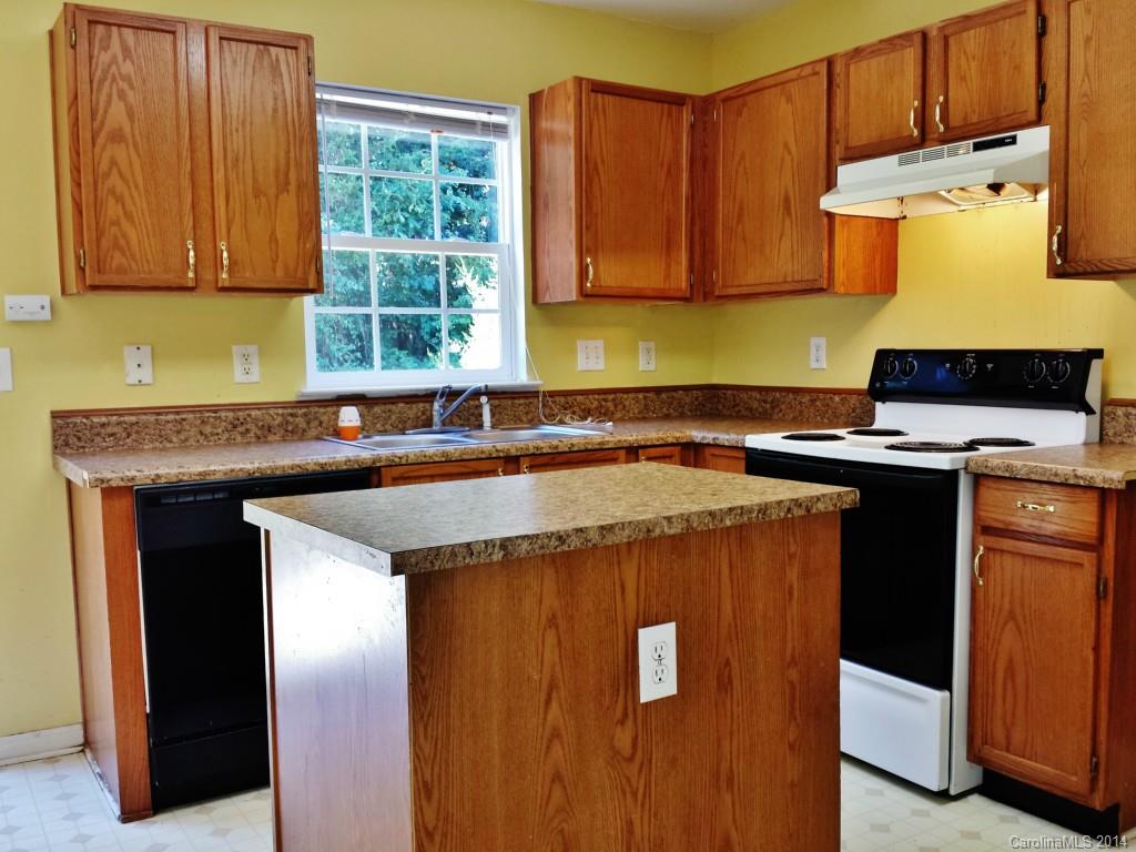 11414 Gold Pan Road Charlotte, NC 28215 - Photo 10 of 24 a kitchen with granite countertop a sink a stove and a wooden cabinets