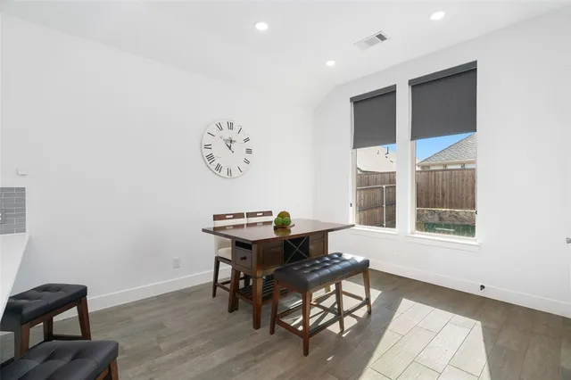 an open kitchen with kitchen island a dining table and chairs