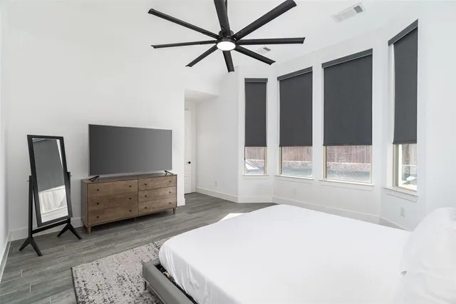 a bedroom with a bed and a ceiling fan