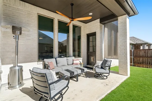 a view of a patio with couches and chairs under an umbrella
