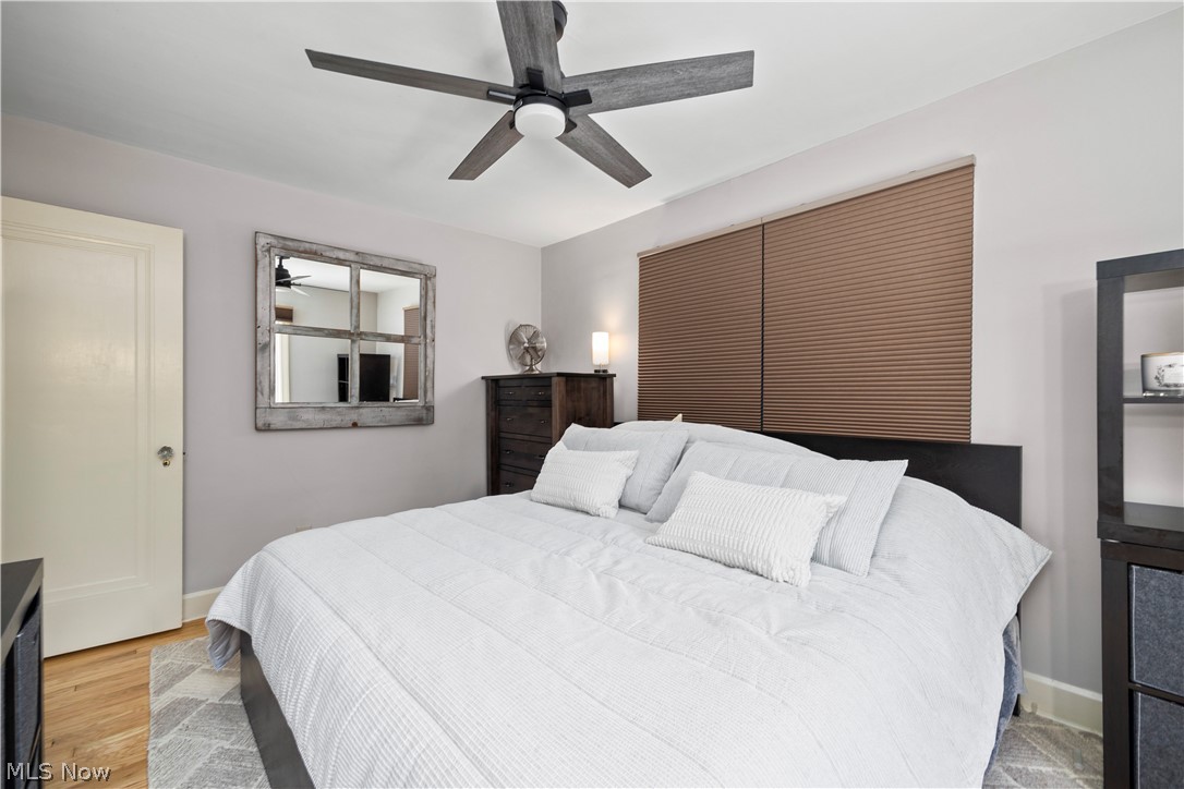 26019 Lake Road Bay Village, OH 44140 - Photo 21 of 40 Interior room featuring a ceiling fan with integrated lighting, window treatments, and wood-finish flooring