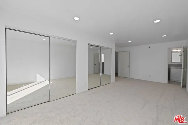 a view of walk in closet with empty racks