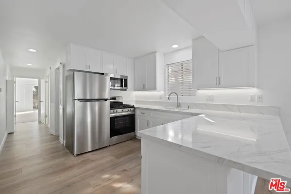a kitchen with stainless steel appliances a refrigerator and a sink
