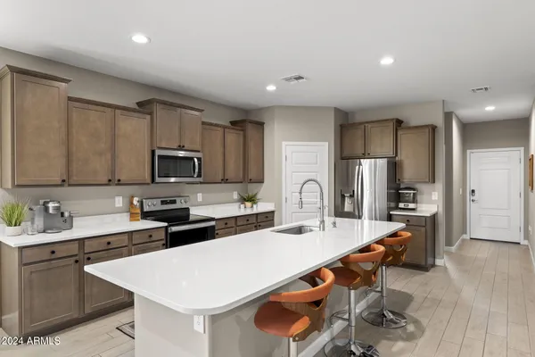 a kitchen with stainless steel appliances a stove a sink a microwave and cabinets