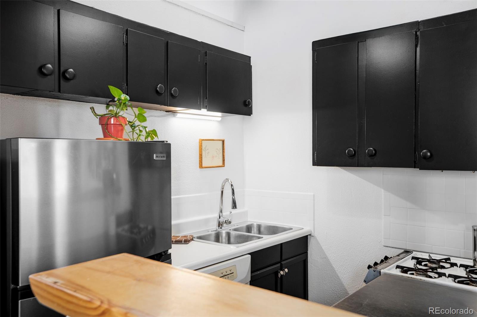 3733 Franklin Street Denver, CO 80205 - Photo 21 of 29 a kitchen with stainless steel appliances a stove a refrigerator and a sink