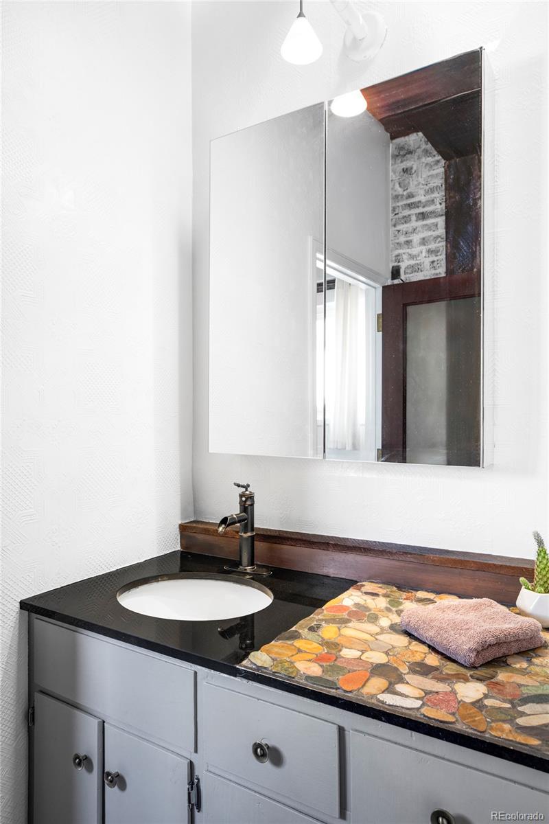 3733 Franklin Street Denver, CO 80205 - Photo 24 of 29 a bathroom with a granite countertop sink and a mirror