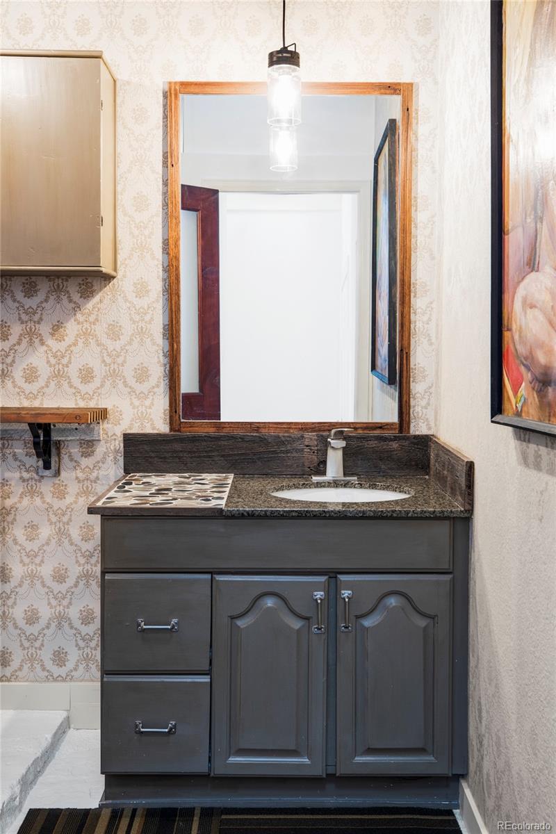 3733 Franklin Street Denver, CO 80205 - Photo 25 of 29 a bathroom with a granite countertop sink and a mirror