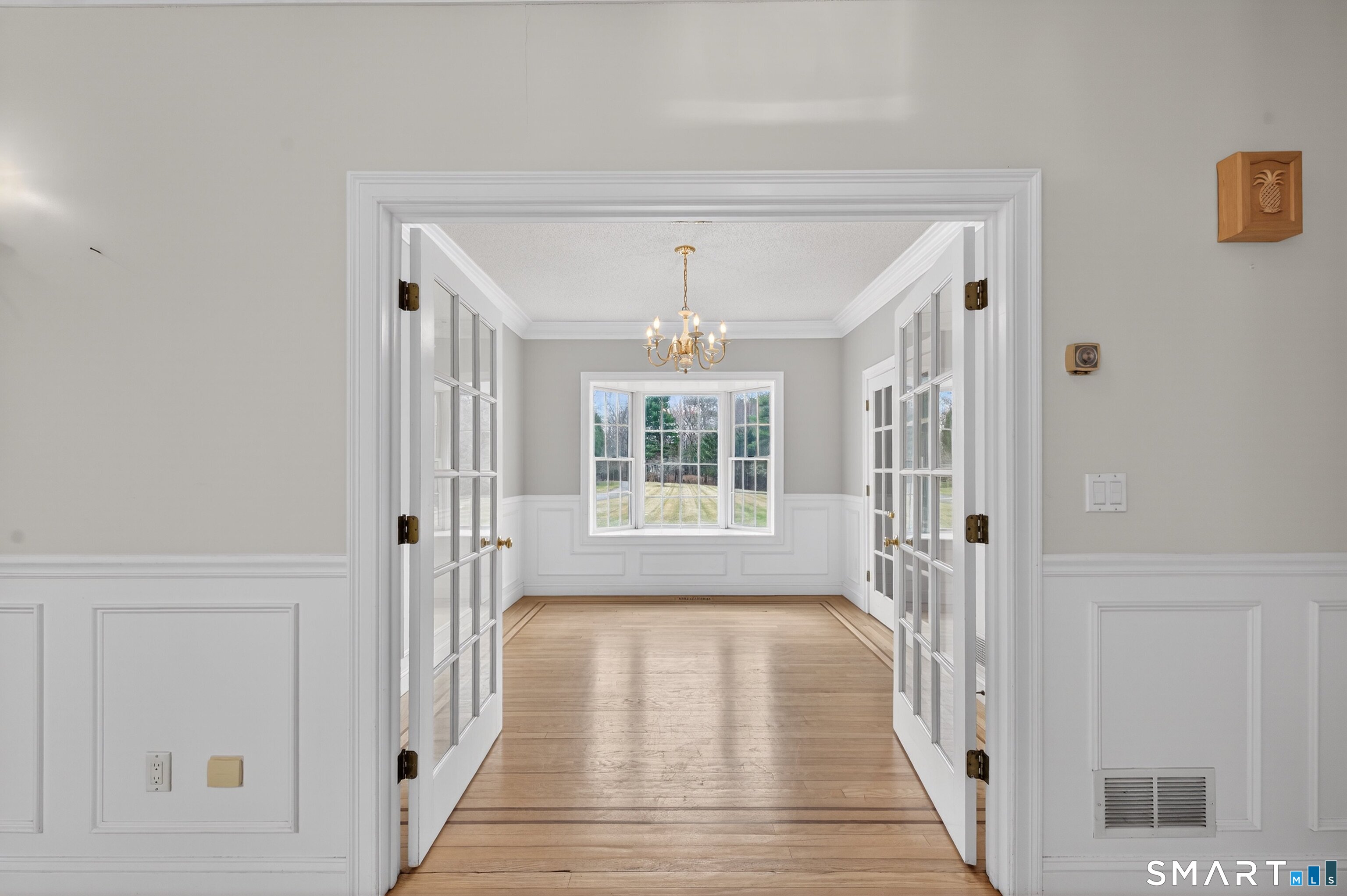 724 Strong Road South Windsor, CT 06074 - Photo 21 of 39 a view of a hallway with wooden floor and a chandelier
