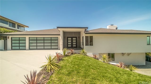 a backyard of a house with table and chairs and potted plants
