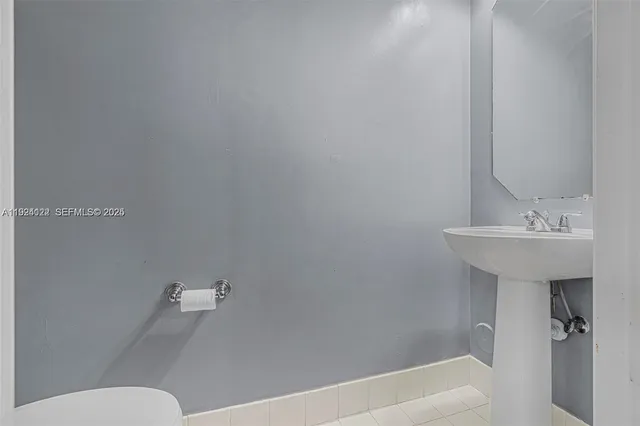 a view of a hallway with wooden floor and a bathroom