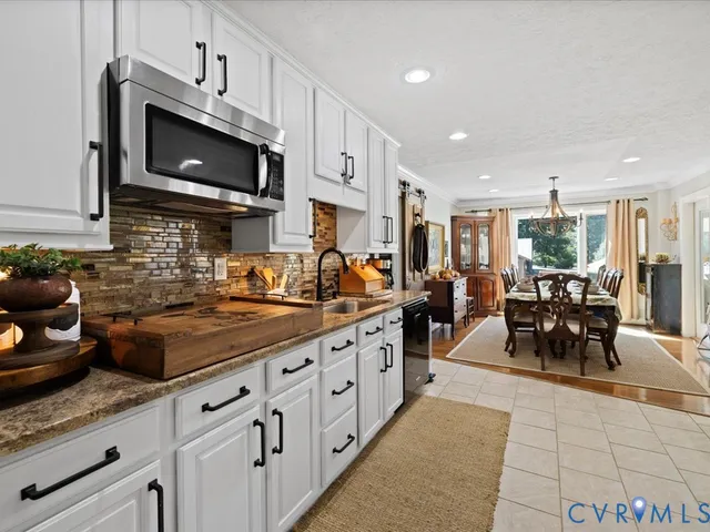 a kitchen with stainless steel appliances granite countertop a sink dishwasher a stove and a microwave oven with granite countertops