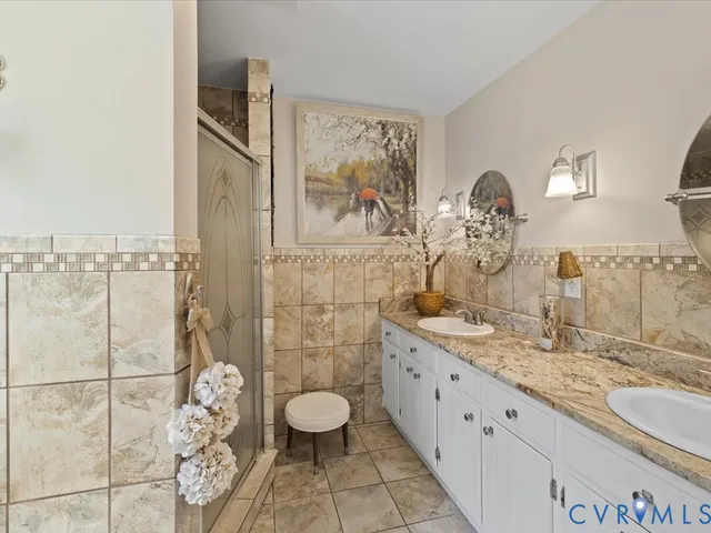 a bathroom with a granite countertop sink mirror vanity and toilet
