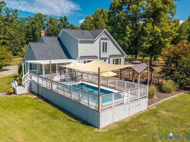 a view of a house with pool and wooden fence