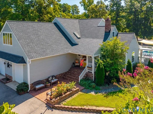 front view of house with a yard and trees in the background