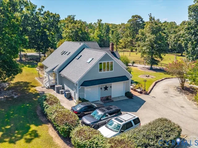 a aerial view of a house with swimming pool lawn chairs and a fire pit