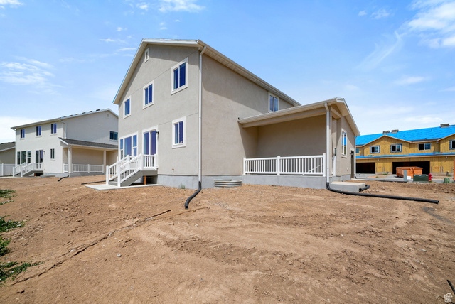 175 West 930 North Santaquin, UT 84655 - Photo 21 of 22 Rear exterior featuring a covered patio with white railing, a walk-out basement entry with a concrete patio, and a second-story balcony