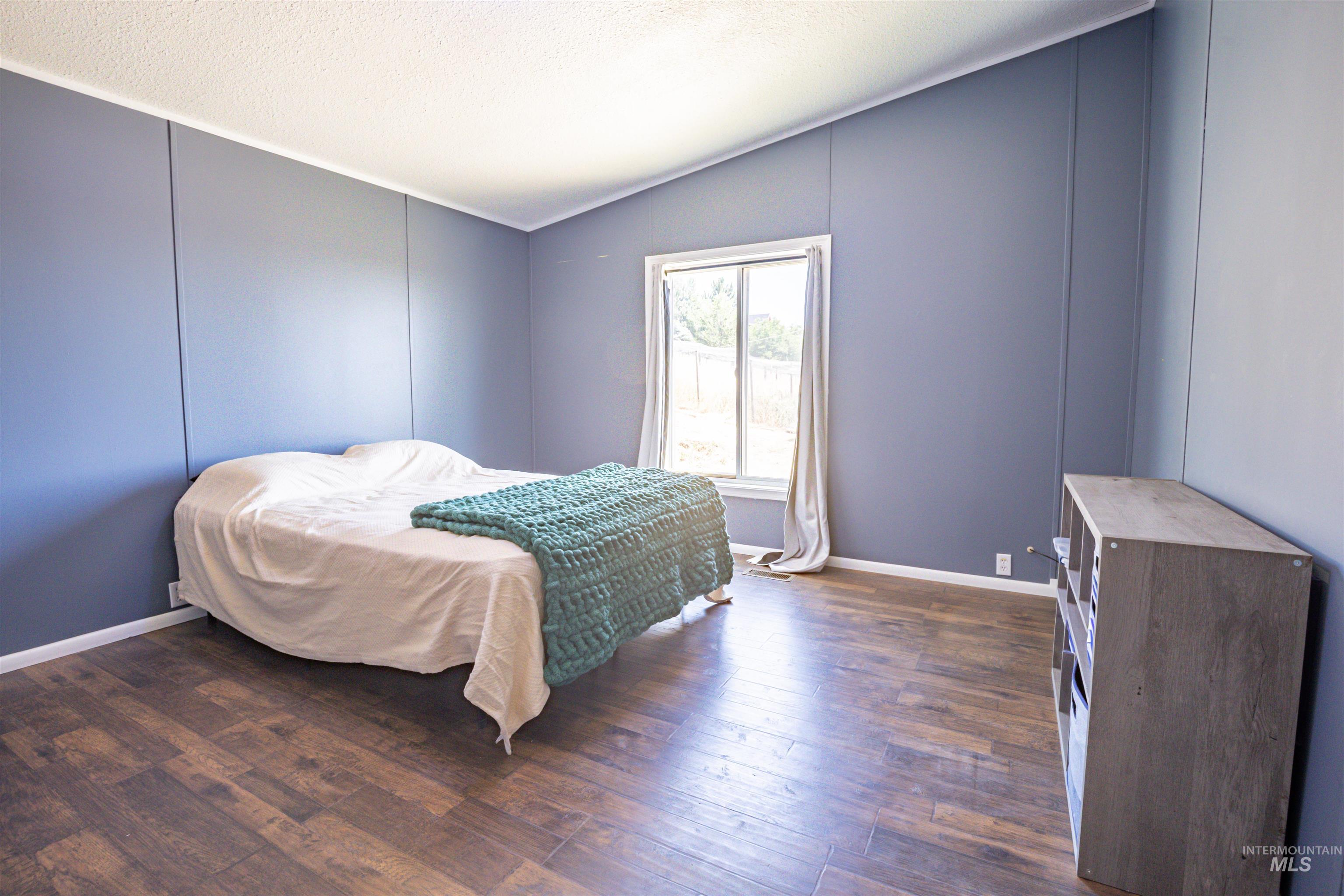 23904 Southview Lane Middleton, ID 83644 - Photo 26 of 29 Interior room featuring wood-finish flooring, a vaulted ceiling, and board and batten style wall panels