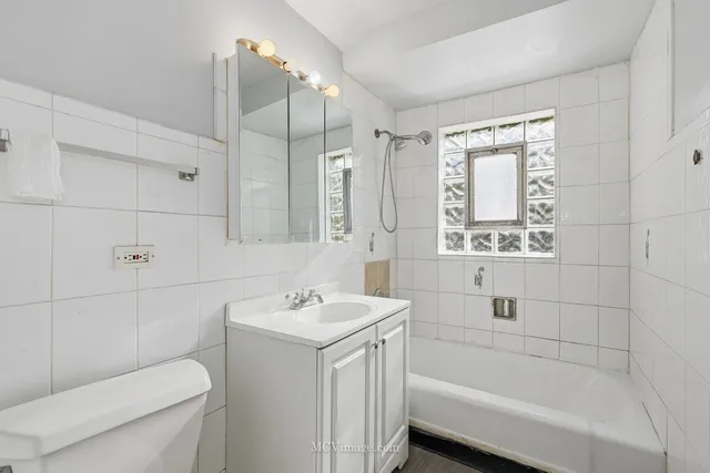 a bathroom with a sink toilet vanity and bathtub