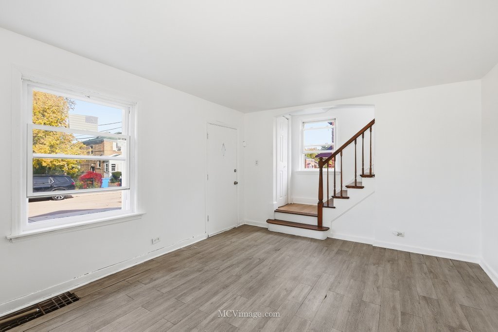 2161 East 97th Street Chicago, IL 60617 - Photo 2 of 13 a view of a room with wooden floor and windows