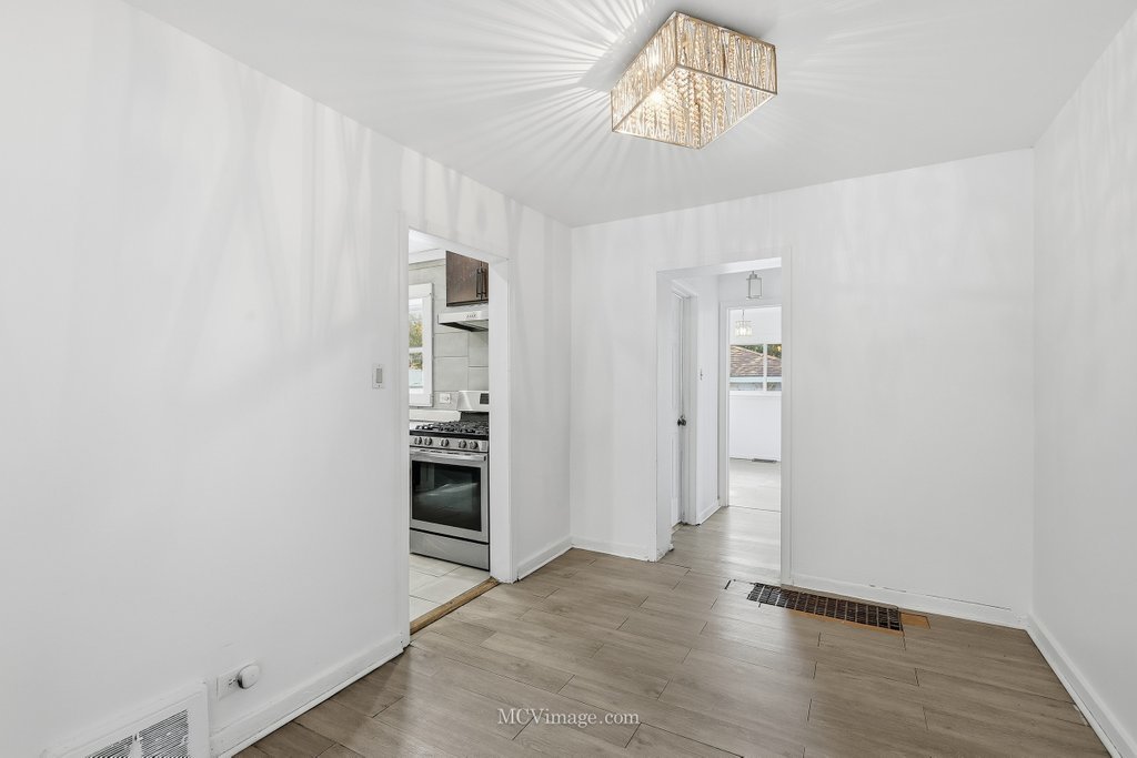2161 East 97th Street Chicago, IL 60617 - Photo 4 of 13 an empty room with wooden floor closet and windows