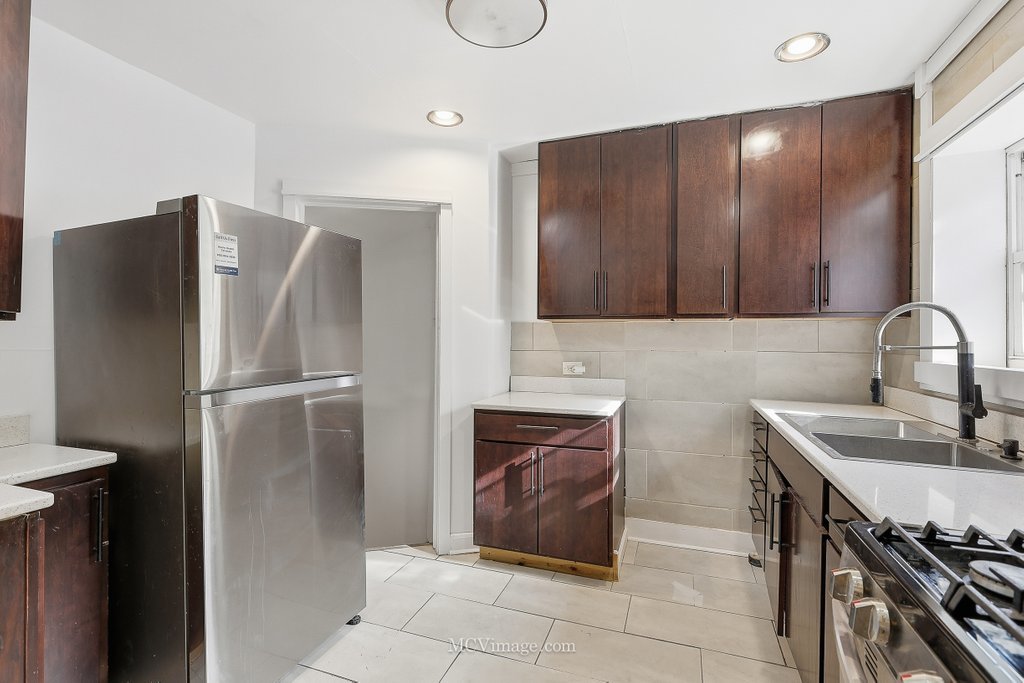 2161 East 97th Street Chicago, IL 60617 - Photo 5 of 13 a kitchen with stainless steel appliances granite countertop a refrigerator and a sink