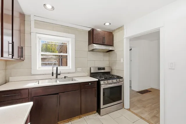 a kitchen with stainless steel appliances a sink stove and cabinets