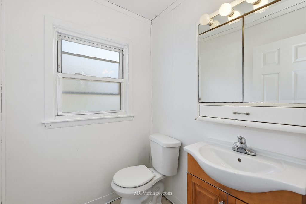 2161 East 97th Street Chicago, IL 60617 - Photo 8 of 13 a bathroom with a sink a toilet and vanity