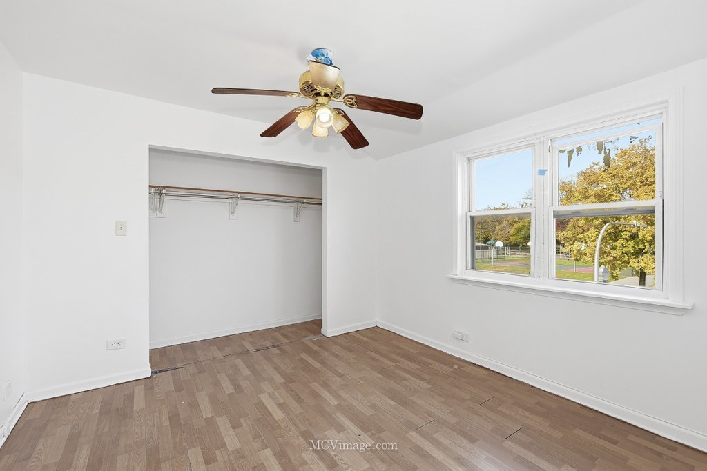 2161 East 97th Street Chicago, IL 60617 - Photo 9 of 13 a view of empty room with wooden floor and fan
