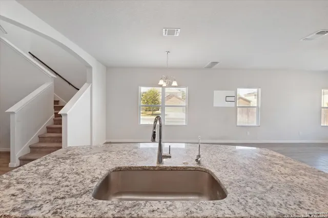 a view of a kitchen sink a faucet cabinets and wooden floor