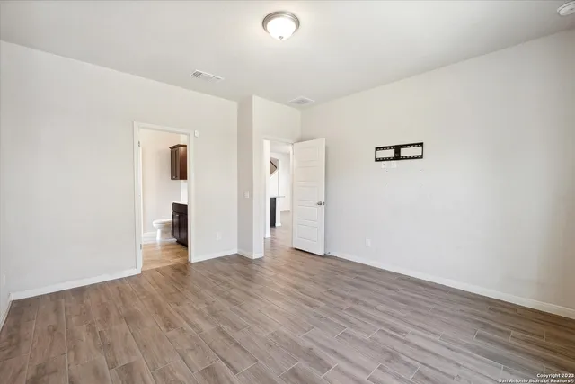 a view of an empty room with wooden floor
