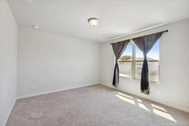 an empty room with a balcony and a potted plant