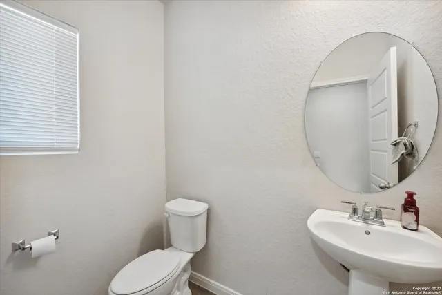 a bathroom with a toilet sink and mirror