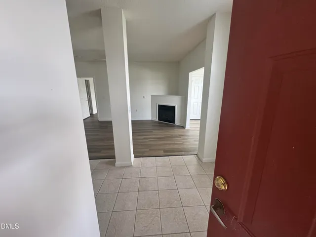 a view of a hallway with wooden cabinets and fireplace