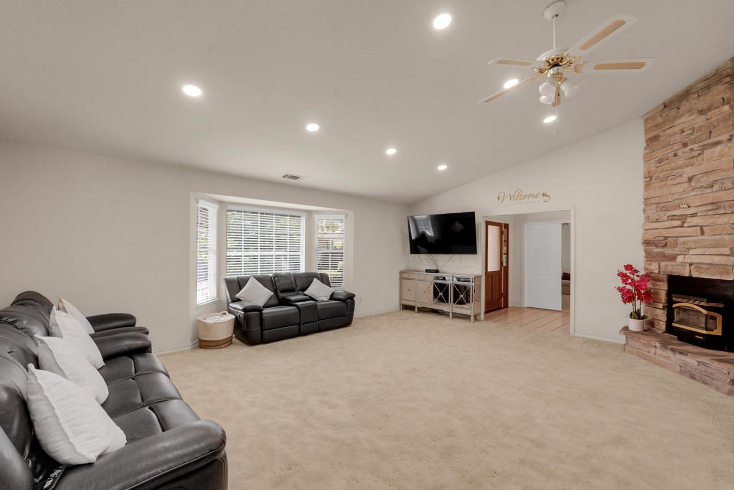 2195 Brigadoon Walk Manteca, CA 95336 - Photo 12 of 41 a living room with furniture a fireplace and a flat screen tv