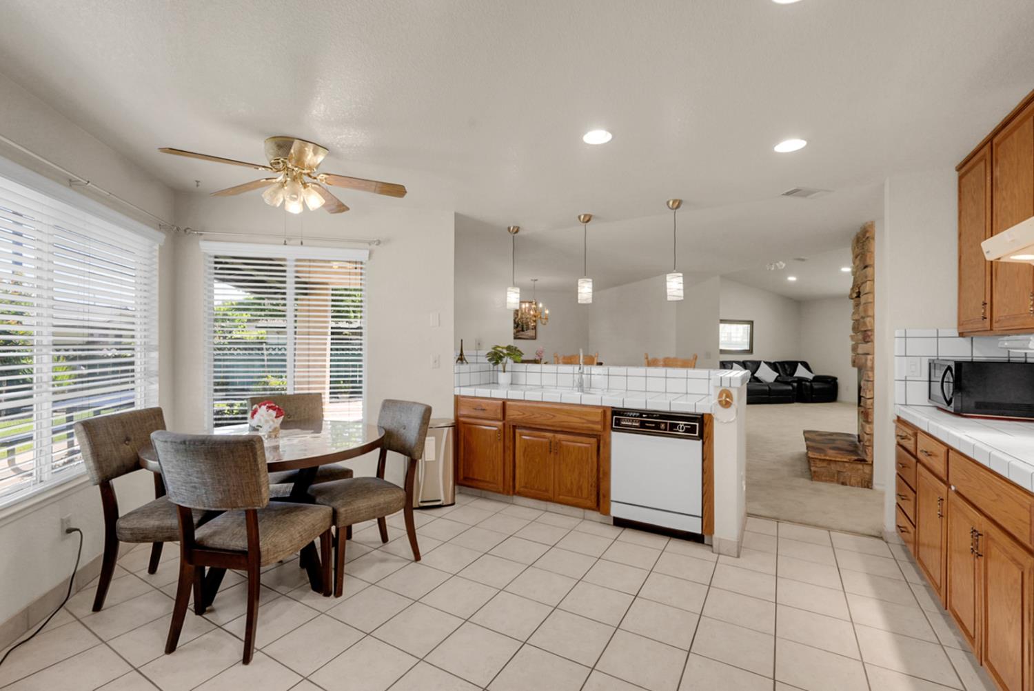 2195 Brigadoon Walk Manteca, CA 95336 - Photo 7 of 41 a kitchen with a dining table chairs sink and cabinets