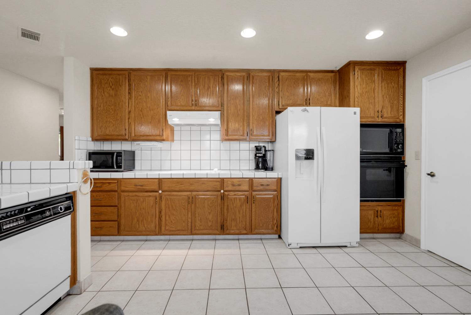 2195 Brigadoon Walk Manteca, CA 95336 - Photo 8 of 41 a kitchen with a refrigerator a stove top oven and cabinets