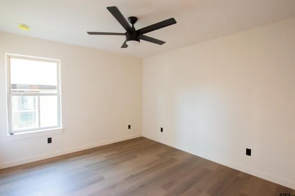 a view of an empty room with wooden floor