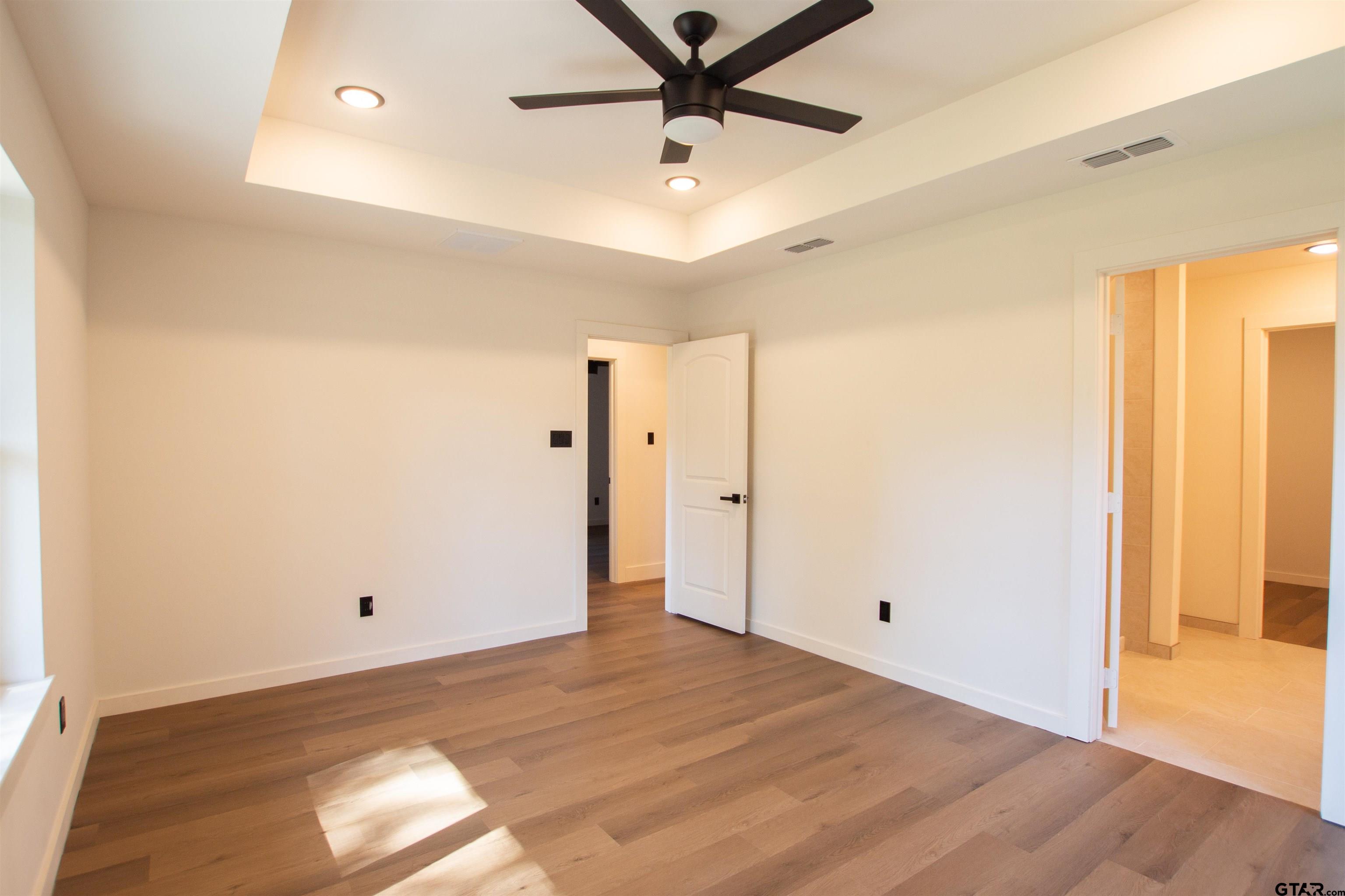 1108 Park Street Tyler, TX 75702 - Photo 20 of 27 a view of a livingroom with wooden floor and a ceiling fan
