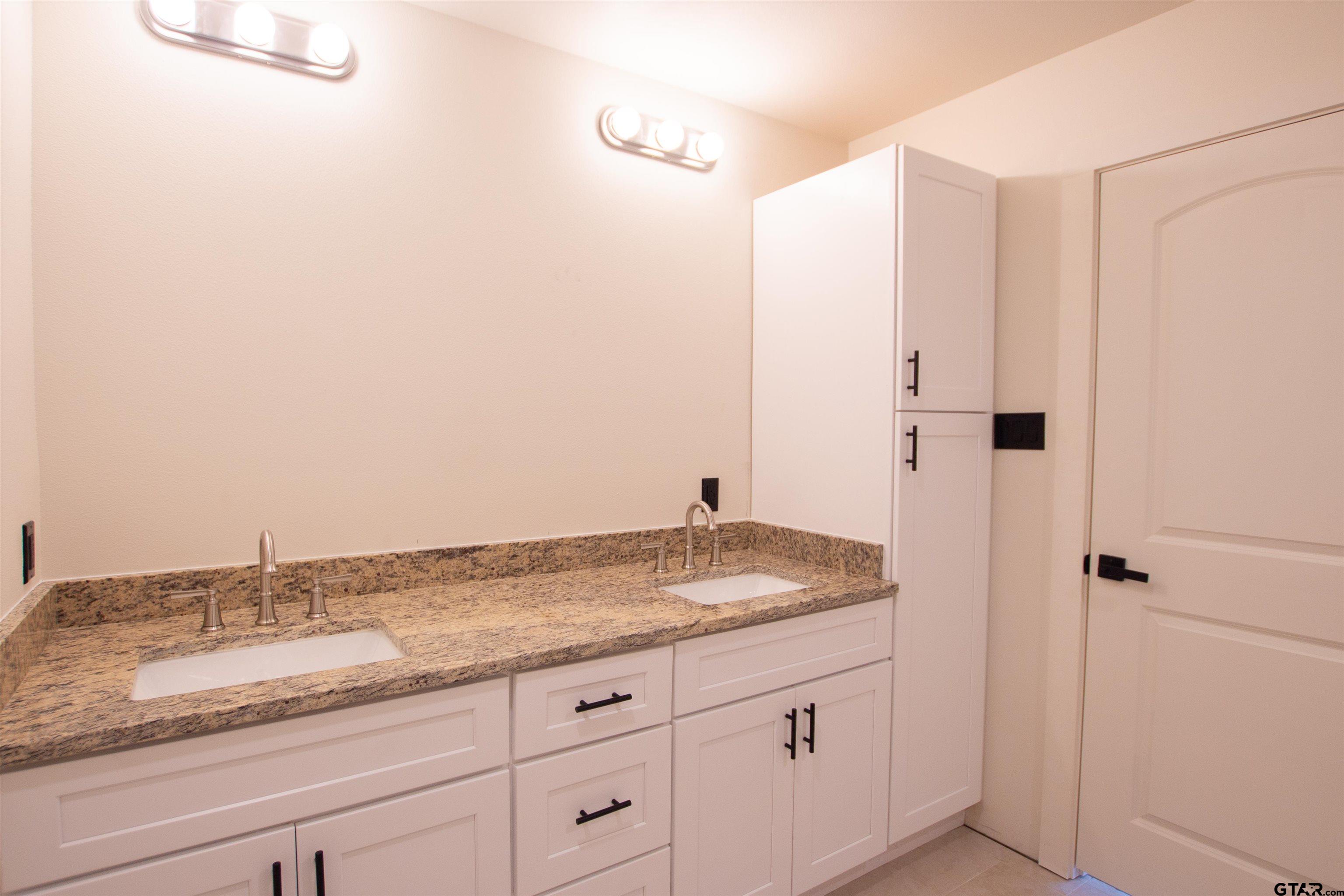 1108 Park Street Tyler, TX 75702 - Photo 21 of 27 a bathroom with a granite countertop sink and mirror