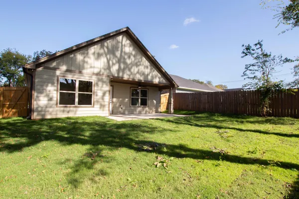 a view of a backyard with wooden fence