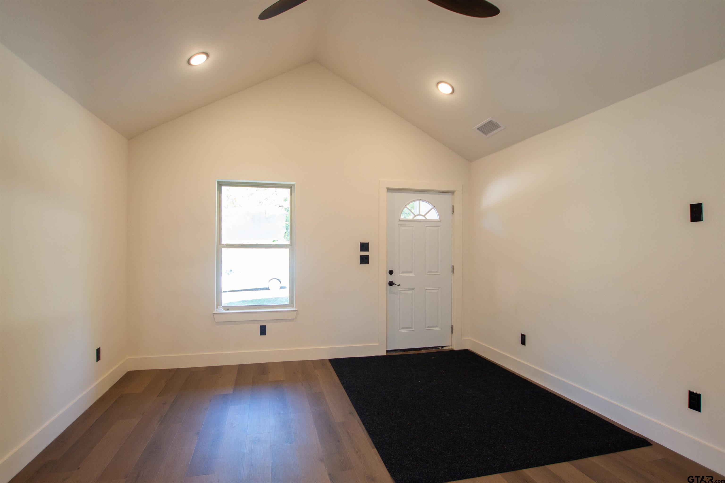 1108 Park Street Tyler, TX 75702 - Photo 3 of 27 an empty room with wooden floor and windows
