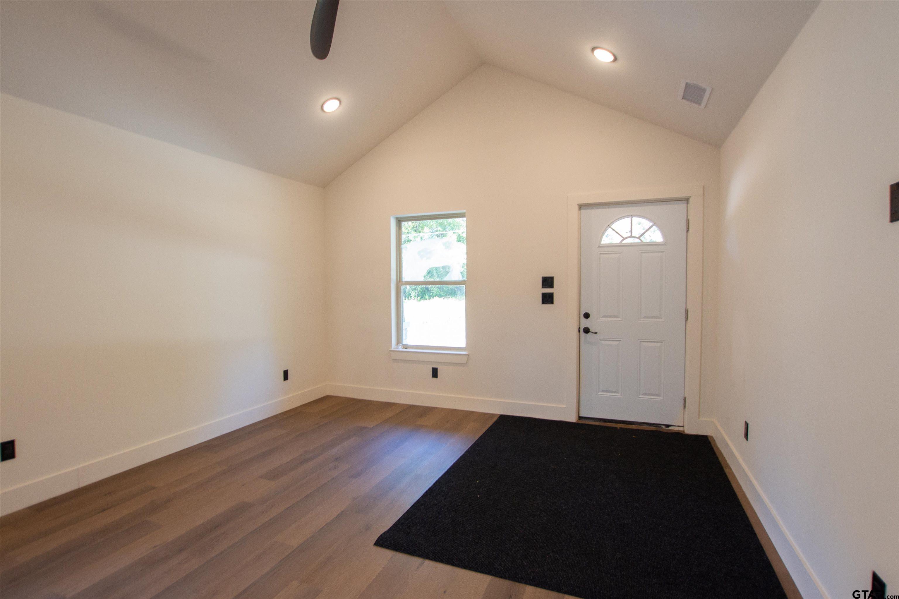 1108 Park Street Tyler, TX 75702 - Photo 4 of 27 an empty room with wooden floor and windows