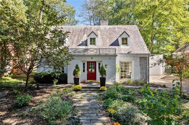 a view of a white house with large windows and a table and chairs