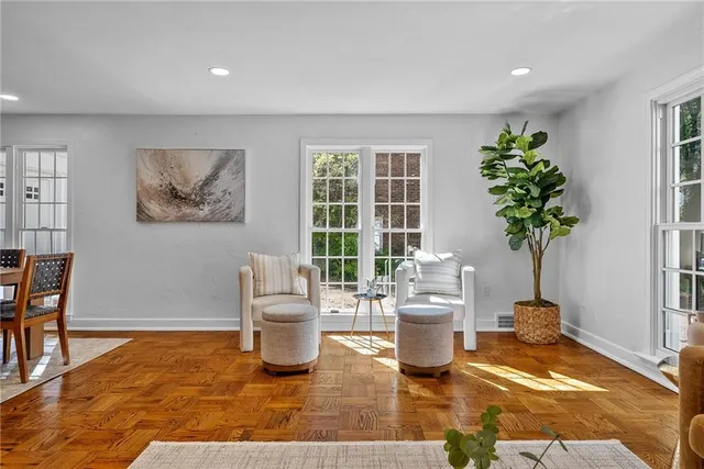 a living room with furniture a potted plant and a large window
