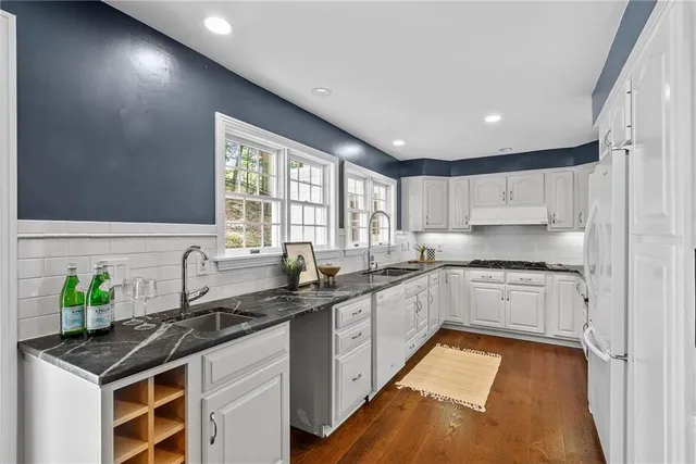 a kitchen with granite countertop a sink stove and cabinets