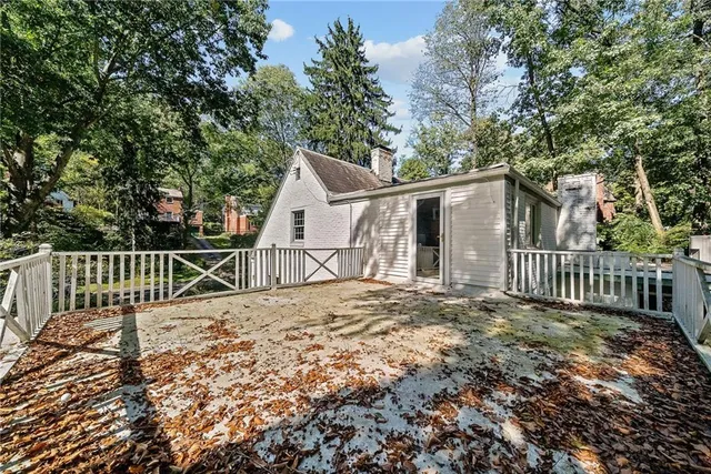 a view of a house with a small yard and wooden fence