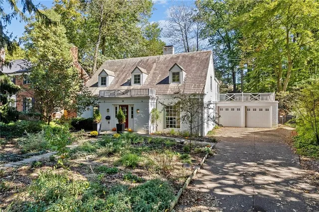 a view of a house with a garden and trees