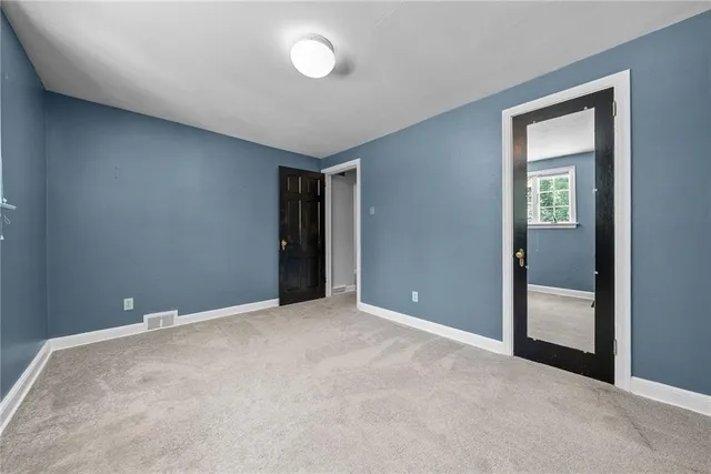 an empty room with closet and a bathroom