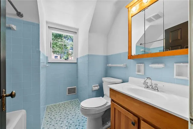 a bathroom with a sink a toilet and a mirror