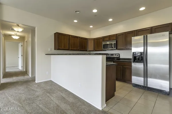 a kitchen with stainless steel appliances granite countertop a refrigerator and a stove
